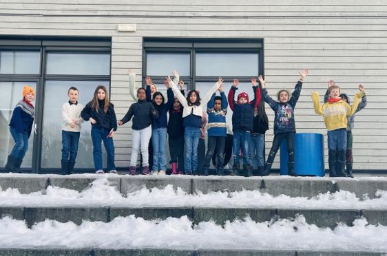 en gruppe mennesker som poserer for et bilde foran en bygning