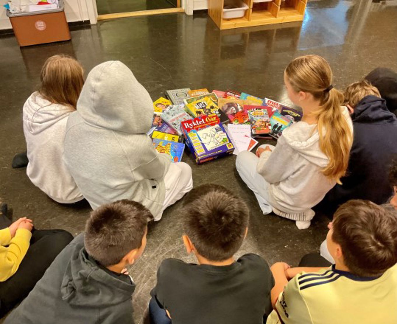 en gruppe mennesker som sitter rundt et bord og spiller et brettspill