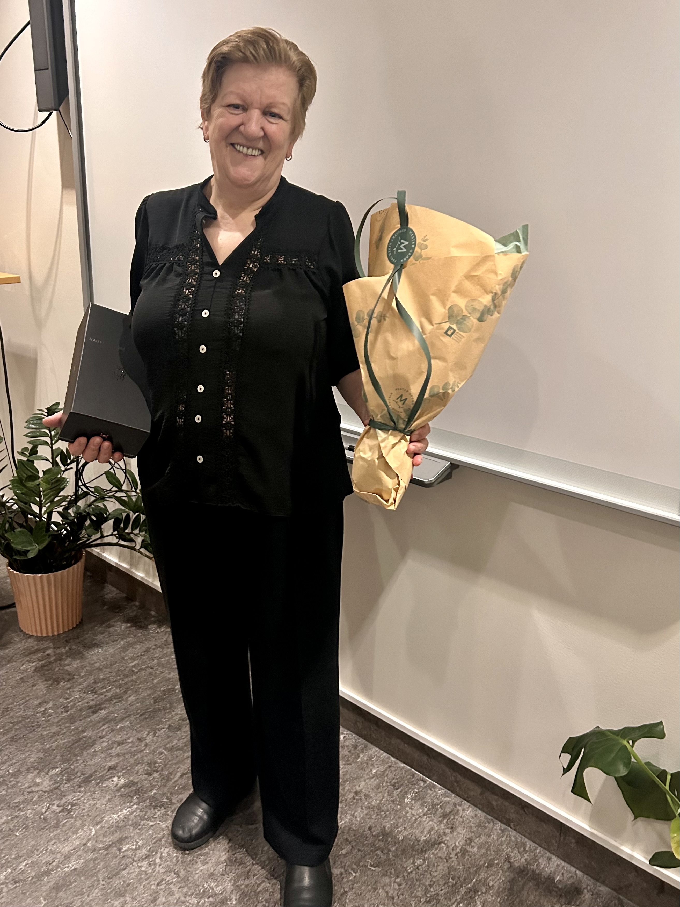 En person som holder en vase og blomster