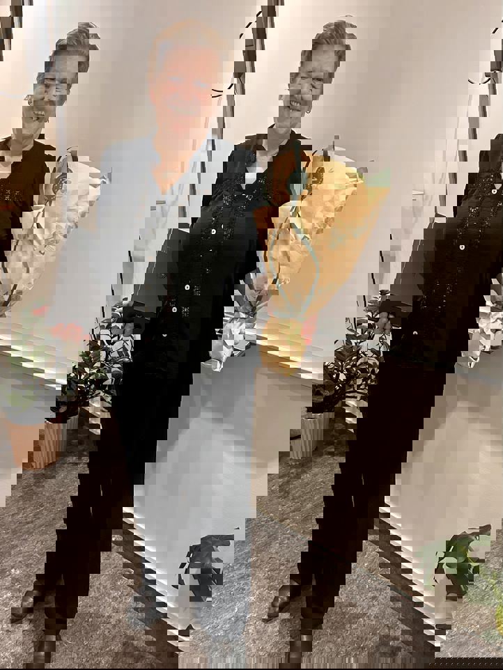 En person som holder en vase og blomster