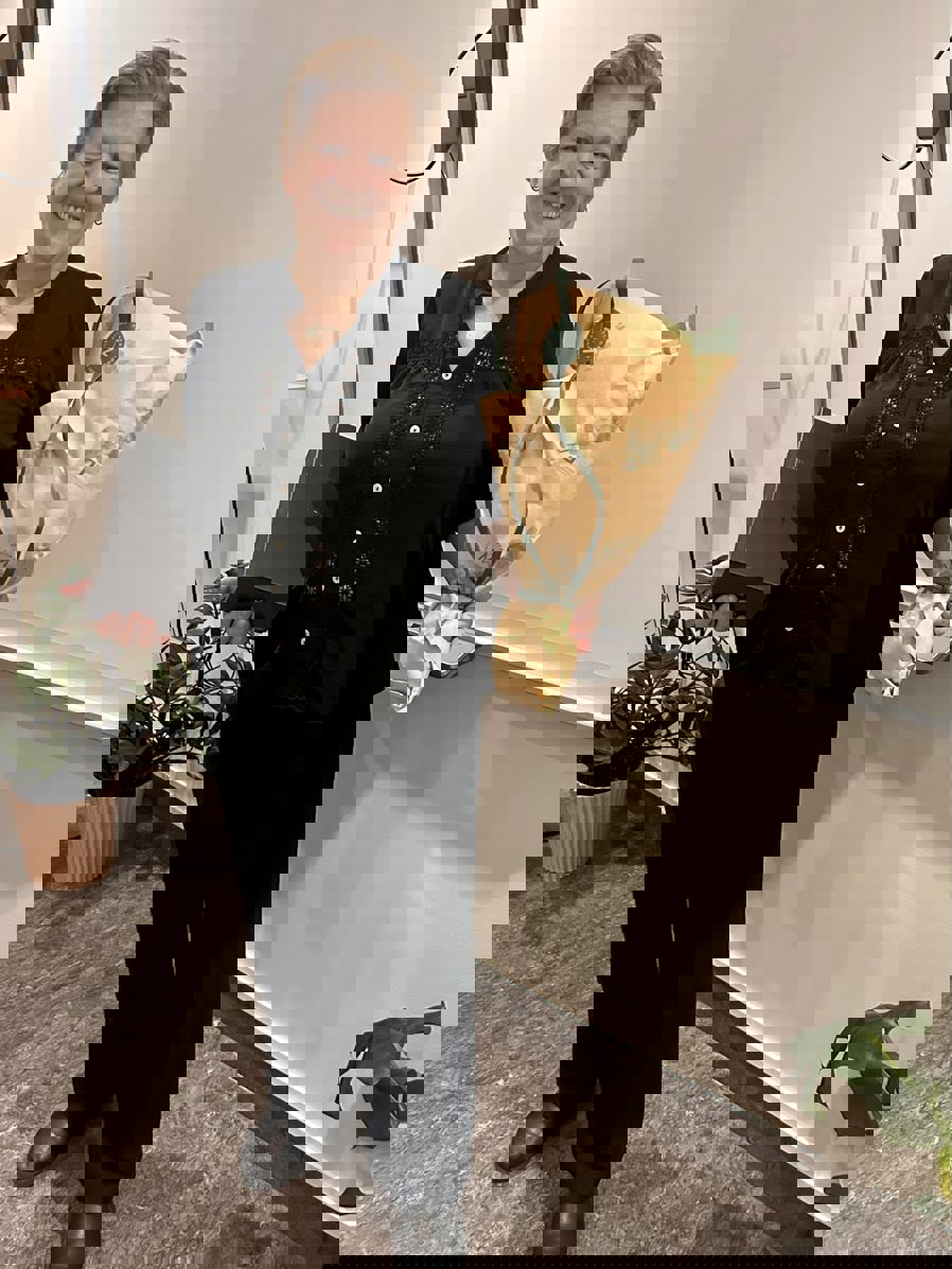 En person som holder en vase og blomster