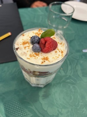 En dessert med krem, kjeks og frukt